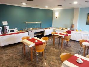 uma sala de jantar com mesas e cadeiras e uma cafetaria em Hotel Acquamaris 3000 em Sanxenxo