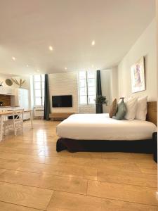 a large bedroom with a large bed and a desk at Les Appartements du Vieux Port in Marseille