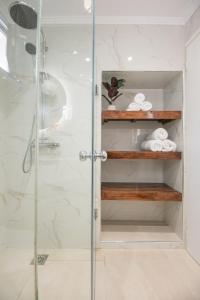 a bathroom with a shower with a glass door at Solomon Premium House in Kritsa