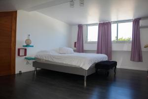 - une chambre avec un lit et des rideaux violets dans l'établissement Le Cerisier côtelé, à Saint-Joseph