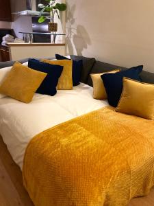 un grande letto con cuscini gialli e blu sopra di St James’ Blvd Newcastle Apartment a Newcastle upon Tyne