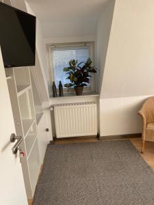 a room with a staircase with a television and a plant at Caros Zimmer Gladbeck in Gladbeck