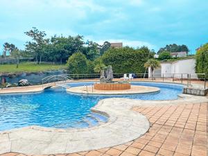 una piscina con una fuente frente a un río en Hotel Acquamaris 3000, en Sanxenxo