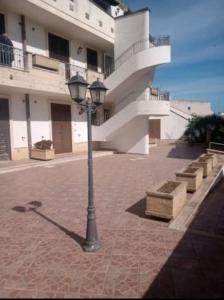 uma luz de rua num passeio de tijolos em frente a um edifício em Salento_Cala Acquaviva a Marina di Marittima (LE) em Marittima