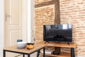 a television sitting on a table in a living room at Le Cocon Castrais in Castres