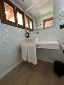 a white bathroom with a sink and a mirror at Hotel El Rosal de Cudillero in Cudillero
