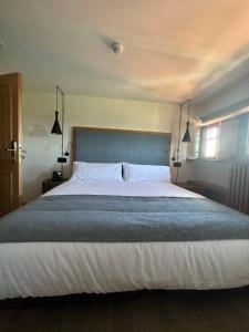 a bedroom with a large white bed with two lamps at Hotel El Rosal de Cudillero in Cudillero
