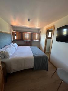a hotel room with a large bed and a television at Hotel El Rosal de Cudillero in Cudillero