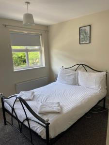 Schlafzimmer mit einem Bett mit weißer Bettwäsche und einem Fenster in der Unterkunft House number 4 Sleeps up to 5 with Smart TVs in every room in Wellington