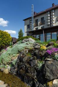 un jardín de rocas con flores frente a un edificio en Kamelot en Ternopilʼ