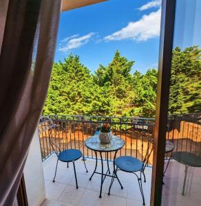 een tafel en stoelen op een balkon met uitzicht bij Morello Beach Hotel in Marina di Pescoluse