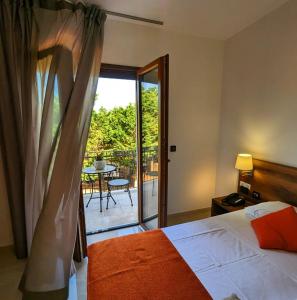 a bedroom with a bed and a balcony with a table at Morello Beach Hotel in Marina di Pescoluse