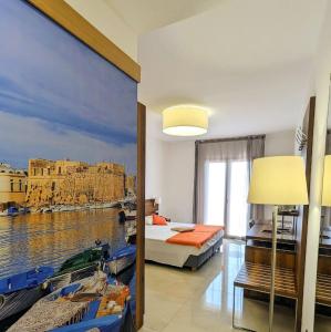 a bedroom with a large painting of a harbor at Morello Beach Hotel in Marina di Pescoluse