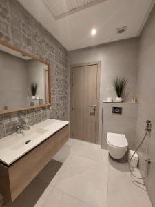 La salle de bains est pourvue de toilettes, d'un lavabo et d'un miroir. dans l'établissement Très bel appart climatisé proche de la plage, à Agadir