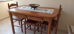 - une table en bois avec des chaises et un bol dans l'établissement Apartamento El Pórtico de Muros, à Muros de Nalón