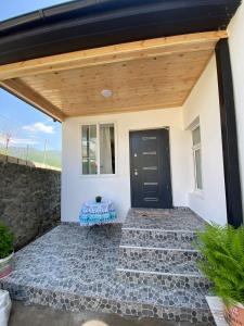 a house with a black door and a stone patio at Dream House Oguz in Oğuz