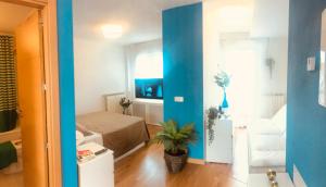 a room with a blue wall and a room with a bed at PENTHOUSE INDEPENDIENTE a 3 paradas en metro de ATOCHA (estacion central Madrid) in Madrid