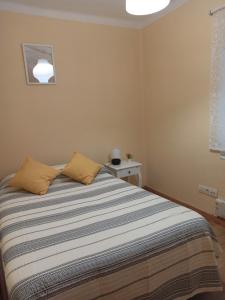 - une chambre avec un lit et une couverture rayée dans l'établissement Apartamento El Pórtico de Muros, à Muros de Nalón