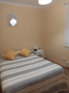 a bedroom with a bed with a striped blanket at Apartamento El Pórtico de Muros in Muros de Nalón