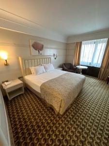 a hotel room with a bed and a chair at Surmeli Istanbul Hotel in Istanbul