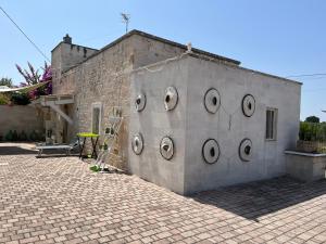 un bâtiment en briques avec des fenêtres circulaires sur son côté dans l'établissement Il Villino di GRAZIO, à Monopoli