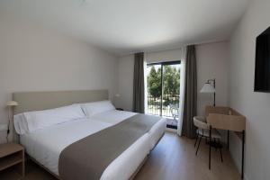 Un dormitorio con una gran cama blanca y una ventana en Hotel H4 Cangas 3 Superior, en Cangas de Morrazo