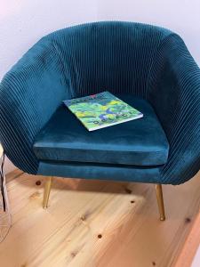 ein blauer Stuhl mit einem Buch darüber in der Unterkunft Back to Basics in Nikšić
