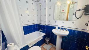 a blue and white bathroom with a tub and a sink at Apartamento Jimena Cadiz en el centro de Nerja in Nerja