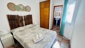 a bedroom with a bed with two towels on it at Apartamento Jimena Cadiz en el centro de Nerja in Nerja