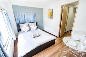 Un pequeño dormitorio con una cama y una mesa. en 10min walk to Shinjuku YoY5, en Tokio