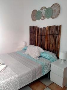 Apartamento Jimena Cadiz en el centro de Nerja في نيرخا: غرفة نوم مع سرير مع اللوح الأمامي الخشبي
