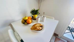 a white table with two bowls of fruit on it at Apartamento Jimena Cadiz en el centro de Nerja in Nerja +14 photos