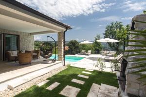 een achtertuin met een zwembad en een huis bij Casa Maya Deluxe Appartment with a pool in Opatija