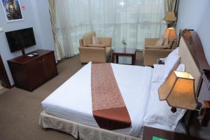 a hotel room with a bed and a living room at Debredamo Hotel in Addis Ababa