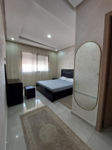 - une chambre avec un lit et un grand miroir dans l'établissement Très bel appart climatisé proche de la plage, à Agadir