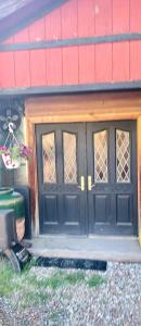 a garage with black doors on a house at Wanderer Studio, AN OFF GRID MOUNTAIN Guest Studio With Fantastic Views in Glenwood Springs