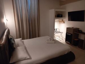 una camera con un letto bianco e una sedia di Dimora50 a Porto Recanati