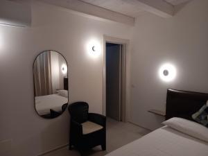 a bedroom with a mirror and a chair and a bed at Dimora50 in Porto Recanati