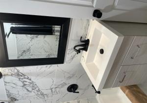 a bathroom with a white counter top and a sink at NORTHERN MOTEL in Sault Ste. Marie