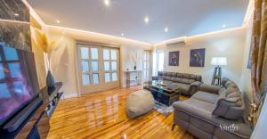 a living room with a couch and a flat screen tv at Luxury Apartment Black and Gold in Mostar +44 photos