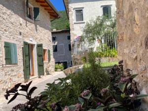 eine Gasse zwischen zwei Steingebäuden mit Blumen in der Unterkunft Ari’sNest in Caprino Veronese