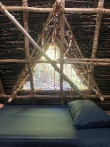 um quarto com uma cama num telhado de madeira em Nebula Nest Cafe & Hostel em Auroville