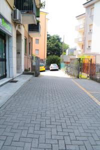 une rue pavée avec une voiture garée dans la rue dans l'établissement GUEST HOUSE SIMONAZZI, à Reggio d'Émilie