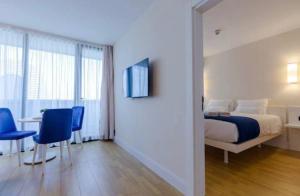 バトゥミにあるOrbi City Hotel Group Batumiのベッドルーム1室(ベッド1台、テーブル、椅子付)