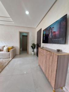 uma sala de estar com uma grande televisão de ecrã plano na parede em Très bel appart climatisé proche de la plage em Agadir