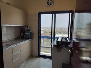 uma cozinha com uma janela com vista para um edifício em Prem Home Stay em Sharjah