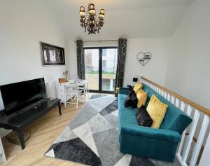 sala de estar con sofá azul y TV en Salt Yard Cottage No 3 en Whitstable