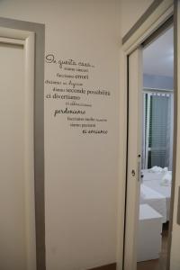 un mur avec une écriture dans une salle de bains dans l'établissement GUEST HOUSE SIMONAZZI, à Reggio d'Émilie