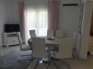 uma sala de jantar com uma mesa e cadeiras brancas em Apartments Mare em Banjol