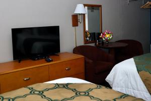 a room with a television on a dresser with a bed at Twi-Lite Inn in Front Royal